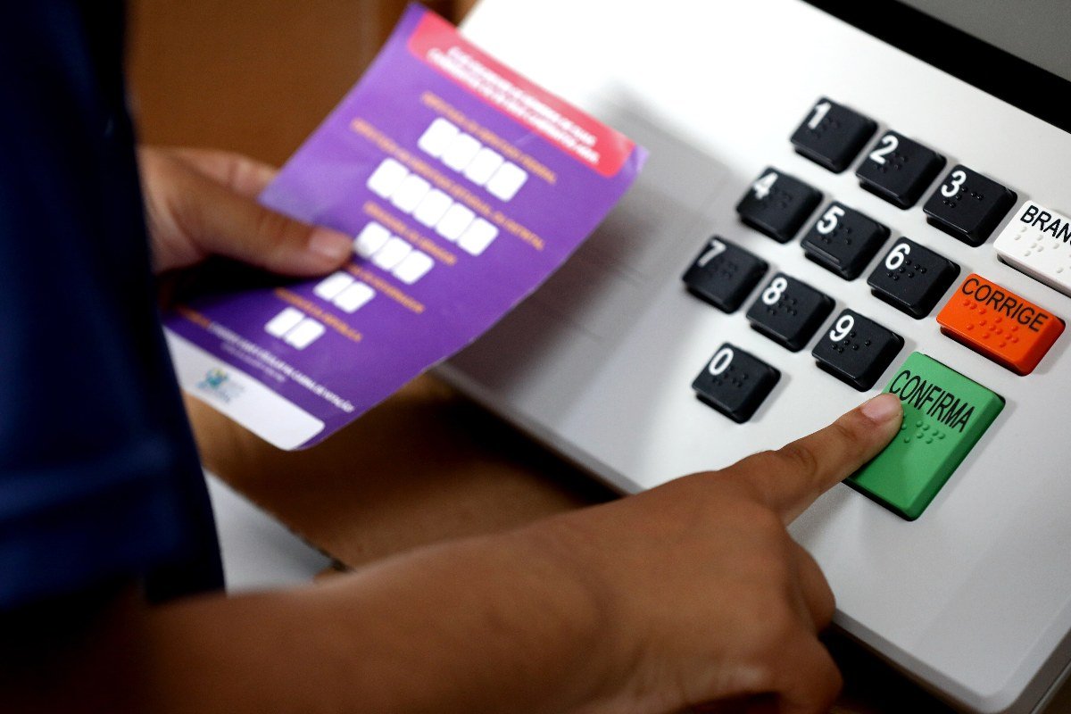 Eleitor aperta a tecla Confirma em urna eletrônica