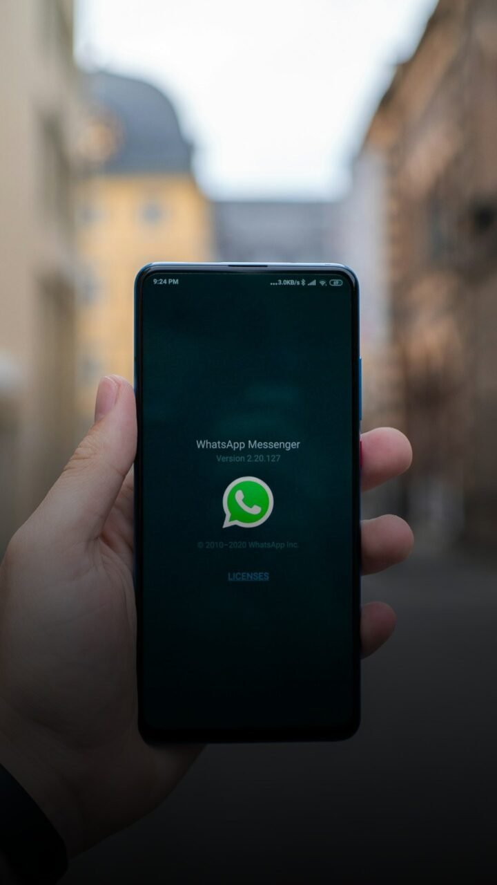 Pessoa segura celular com o WhatsApp aberto na tela